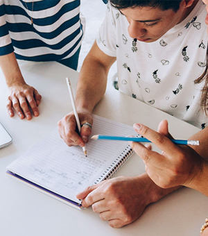 Several people are gathered around a notepad, writing notes