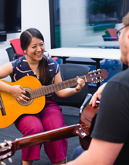 A woman is playing an acoustic guitar