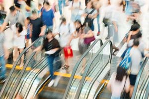 Photograph of people using escalators. 